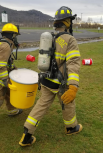 Firefighters carrying a bucket for training