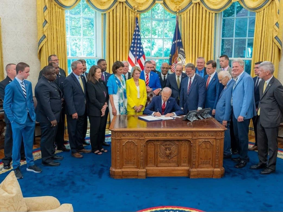 President Biden at desk signing S. 870, the Fire Grants and Safety Act, which reauthorizes AFG, SAFER, and the USFA through September 2028